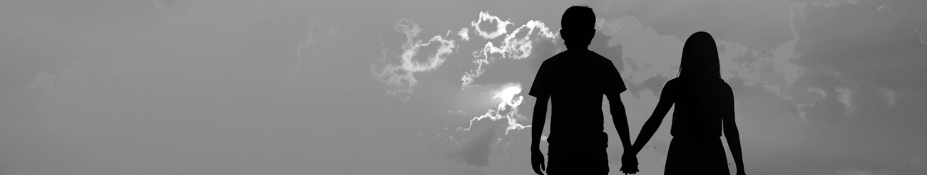 Black and white photo of couple walking into the sunset